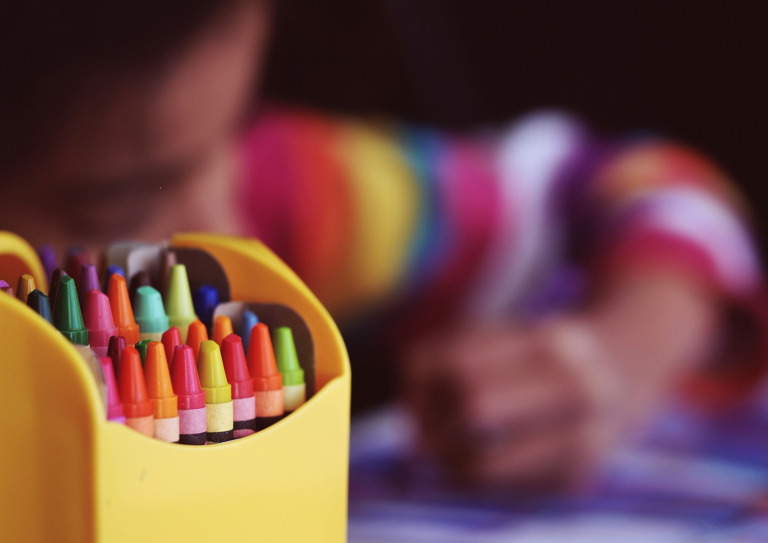 colorful crayons in a yellow box ready for kids' creative play